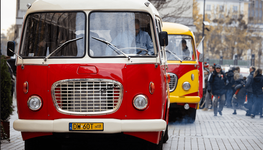 Wyremontowany Ogórek - czerwony autobus marki Jelcz model 43, za nim - pomalowany na żółto inny wyremontowany autobus marki Jelcz model 43 - wersja kabriolet