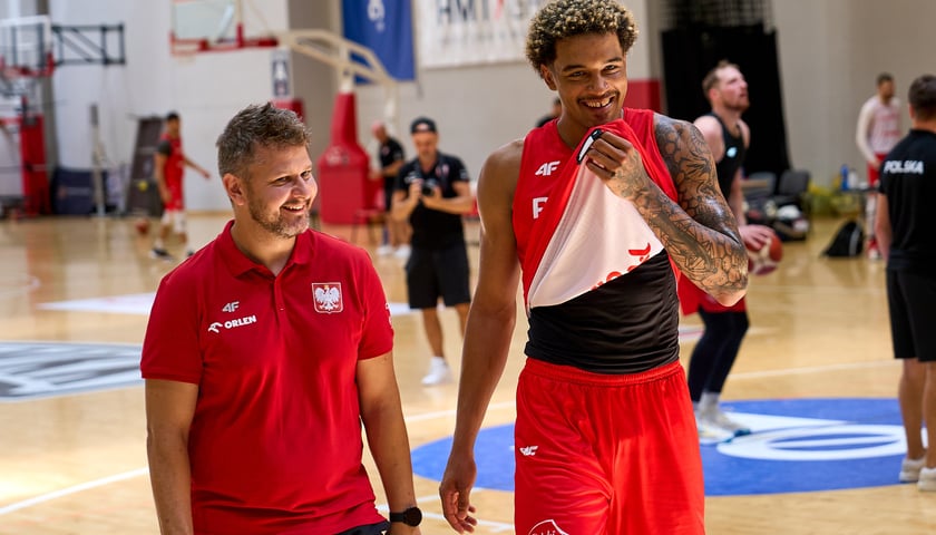 Uśmiechnięty Jeremy Sochan (po prawej) w czerwonym stroju treningowym reprezentacji Polski (hala WKK) 