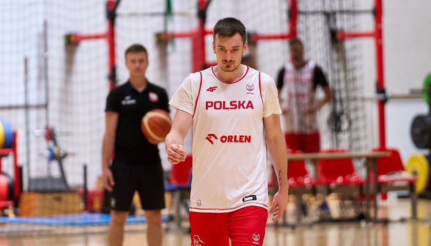 Daniel Gołębiowski w białym stroju treningowym reprezentacji Polski w hali WKK