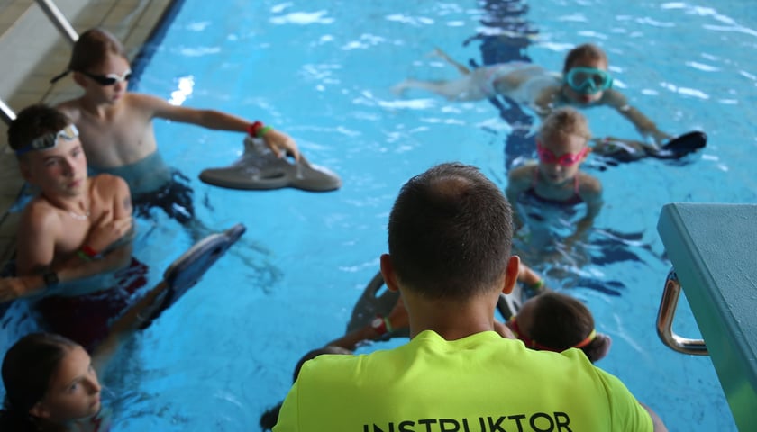 Szkoła pływania we wrocławskim Aquaparku. Na zdjęciu instruktor z dziećmi.