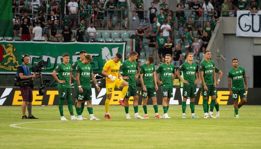 11 piłkarzy Śląska w zielonych strojach na murawie stadionu miejskiego podczas meczu z Lechią