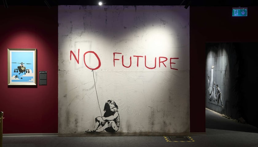 Reprodukcja muralu Banksy'ego „No Future”, przedstawiającego smutną dziewczynkę (z wystawy we Wrocławiu)