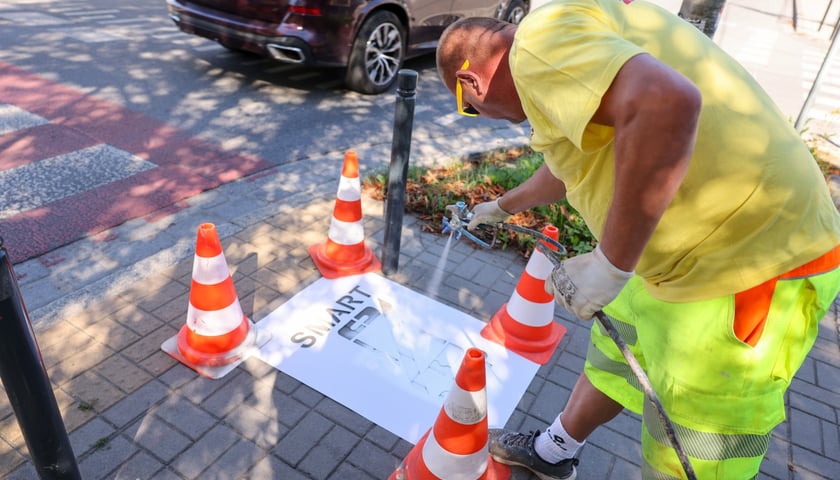 Malowanie z szablonu piktogramu w ramach akcji Stop Smart: przekreślony&nbsp; telefon i napis Smart Stop