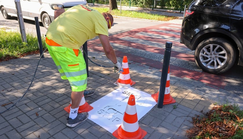 Malowanie z szablonu piktogramu w ramach akcji Stop Smart: przekreślony&nbsp; telefon i napis Smart Stop