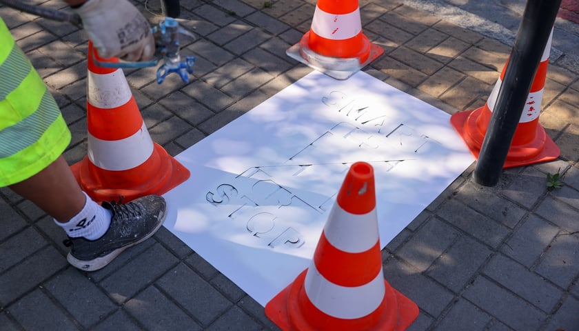 Malowanie z szablonu piktogramu w ramach akcji Stop Smart: przekreślony&nbsp; telefon i napis Smart Stop