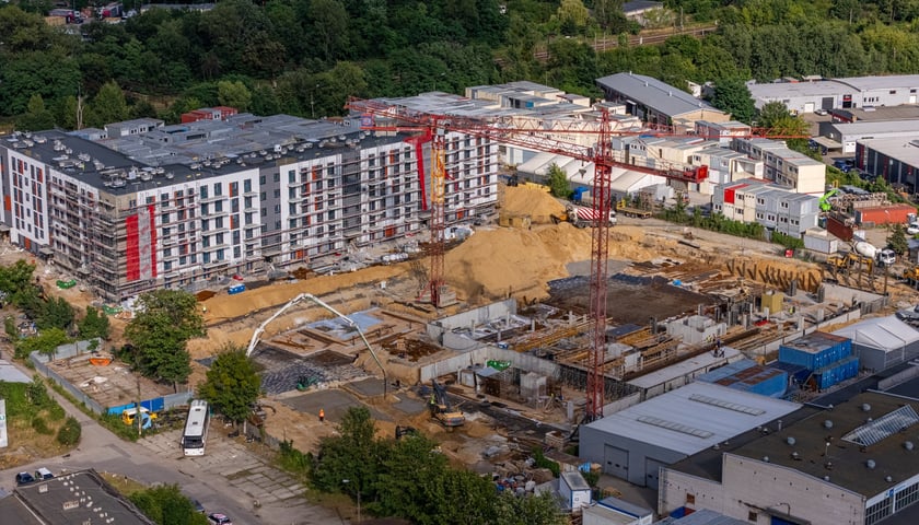 Widok z góry na nowe bloki oraz plac budowy z żurawiem w okolicach ul. Międzyleskiej 