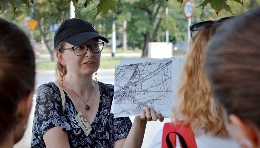 Kobieta opowiadająca coś grupie osób to Monika Glińska, która oprowadza wycieczkę po Psim Polu
