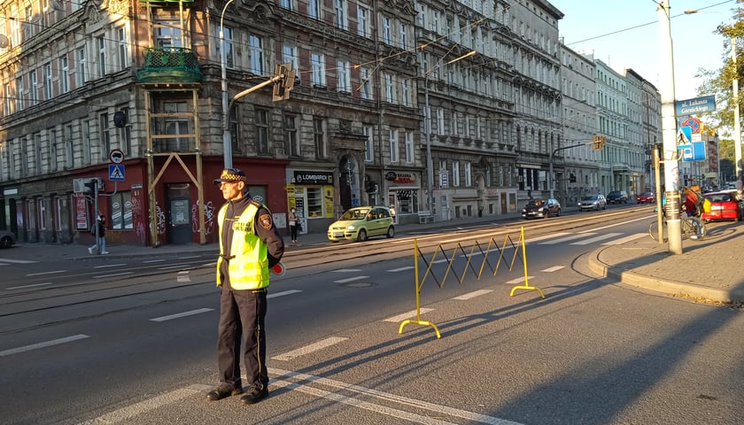 Starżnik miejski stojący przed barierami zamykającymi wjazd na Szkolną Ulicę, tu Górnickiego