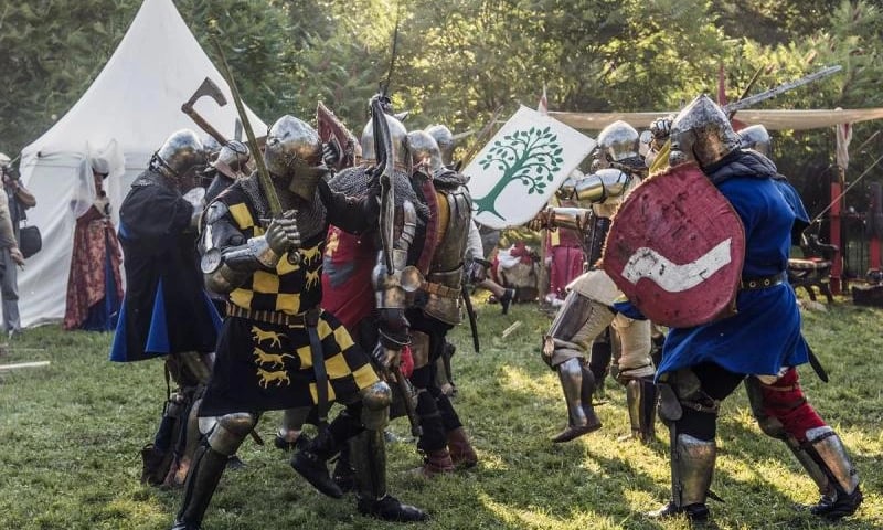 Turniej rycerski w zamku na wodzie w Wojnowicach - na zdjęciu walka na miecze, rycerze mają na sobie zbroje, trzymają broń i tarcze