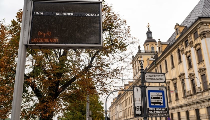 Tablica elektroniczna niewyświetlająca treści przy przystanku Uniwersytet Wrocławski w centrum. Na zdjęciu widać także gmach uczelni