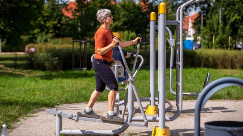 seniorka ćwicząca na siłowni plenerowej, zdjęcie ilustracyjne