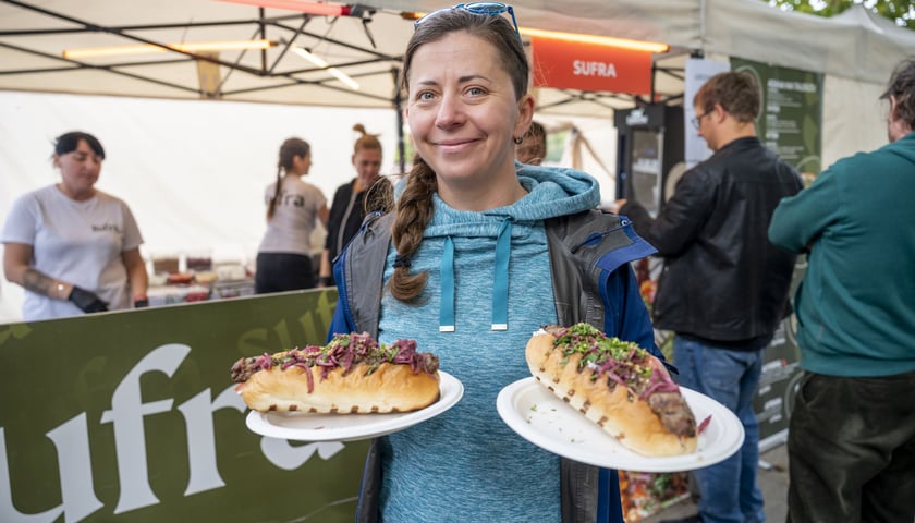 Finał Gastro Miasto. Uśmiechnięta kobieta z dwoma talerzami z potrawami