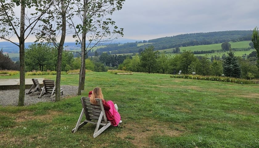 Na zdjęciu kobieta odwrócona tyłem,  w tle Arboretum w Wojsławicach. Zobacz, gdzie jeszcze można wybrać się jesienią na Dolnym Śląsku!