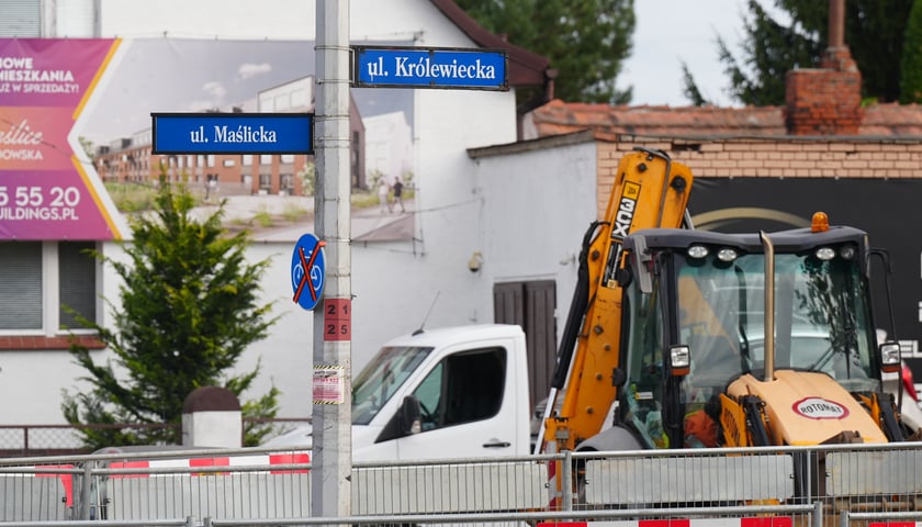 Skrzyżowanie Maślickiej i Królewickiej - widać tabliczki z nazwami ulic, na prawej części zdjęcia - żółta koparka