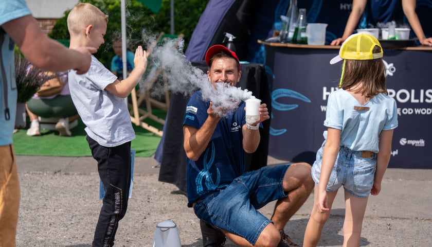 Na zdjęciu dzieci oglądają eksperymenty na stoisku Hydropolis na pikniku TBS na Stabłowicach