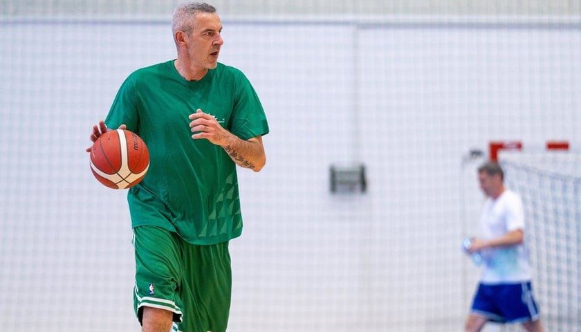 Maciej Zieliński (w zielonej koszulce) kozłuje piłkę w hali AWF-u Wrocław podczas meczu charytatywnego