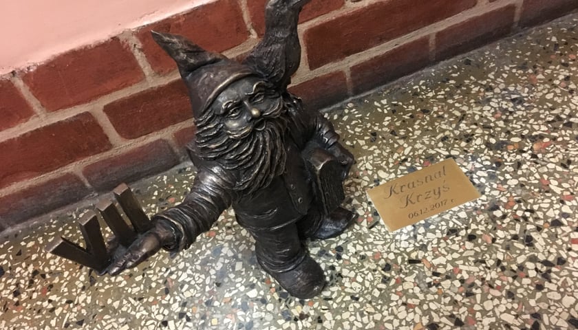 Krasnal Krzyś z krukiem stojący w liceum przy ul. Kruczej