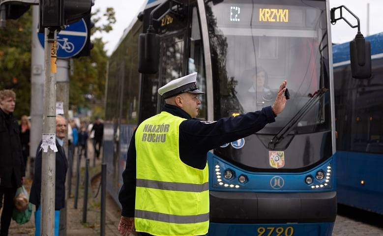 Funkcjonariusz nadzoru ruchu MPK stojący przy tramwaju linii specjalnej E2