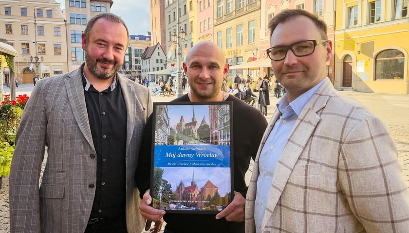 Trzech mężczyzn: w środku Łukasz Stelmach, po lewej stronie Mariusz Kotkowski, prawej Tomasz Sielicki współwłaściciele Wydawnictwa Wrocławski Neptun.