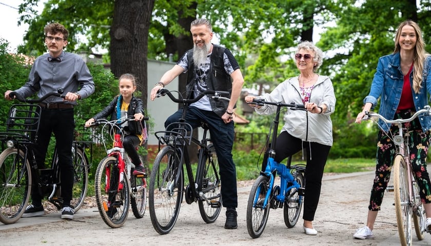 Pięć osób na rowerach: seniorka, kobieta, dziewczynka i dwóch mężczyzn