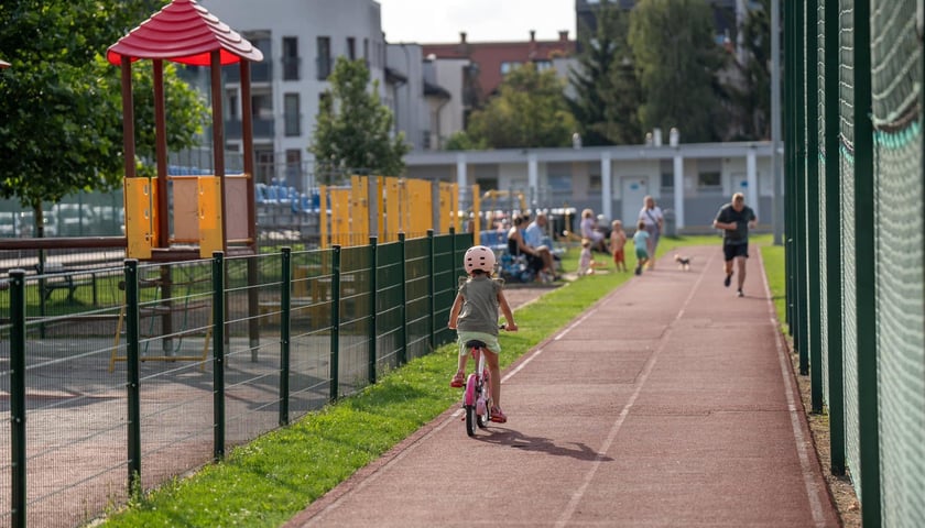 Dziewczynka jadąca rowerem po bieżni na obiekcie sportowym Ołtaszyn