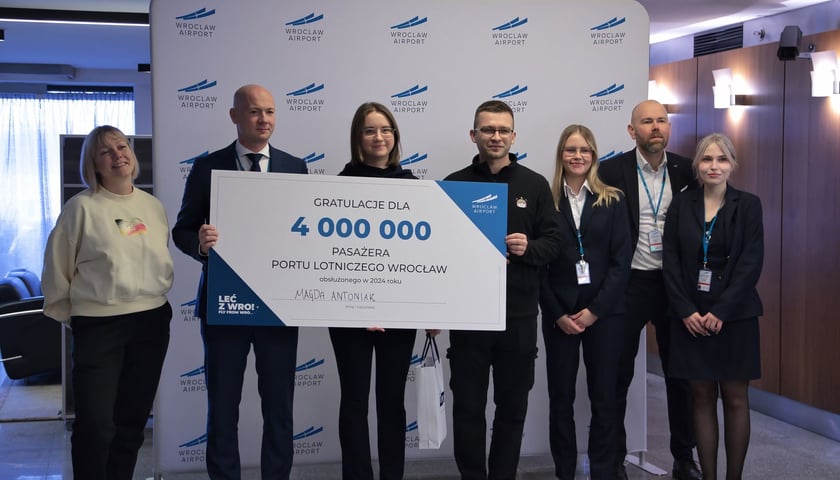 Pani Magda Antoniak z Wrocławia razem z Karolem Przywarą, prezesem wrocławskiego lotniska, trzyma czek z okazji zostania 4-milionową pasażerką w 2024 roku