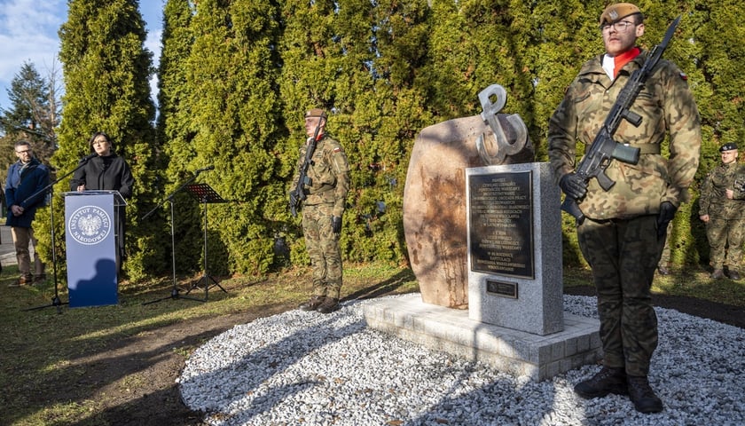 Odsłonięcie Pomnika Cywilnej Ludności Powstańczej Warszawy Deportowanej do Wojennego Wrocławia w Trakcie i Po Upadku Powstania Warszawskiego. Na zdjęciu kamienny obelisk oraz żołnierze na warcie przy pomniku