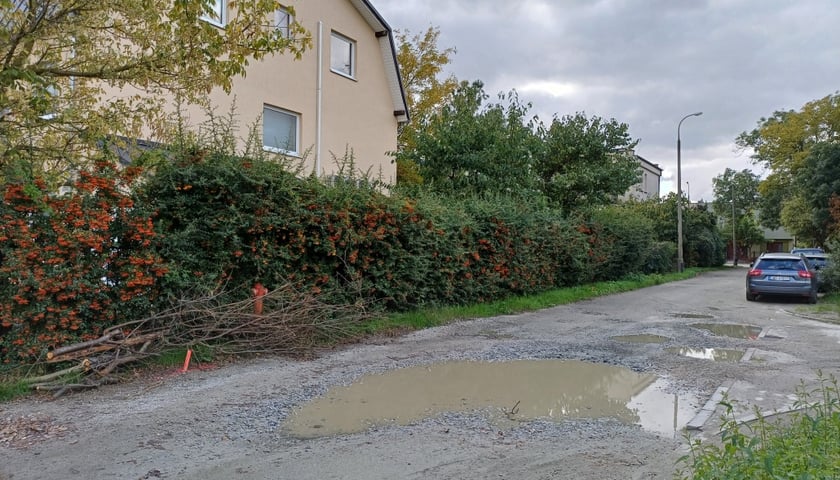 Gruntowy kawałek Pogodnej z kałużą, obok dom (październik, przed remontem)