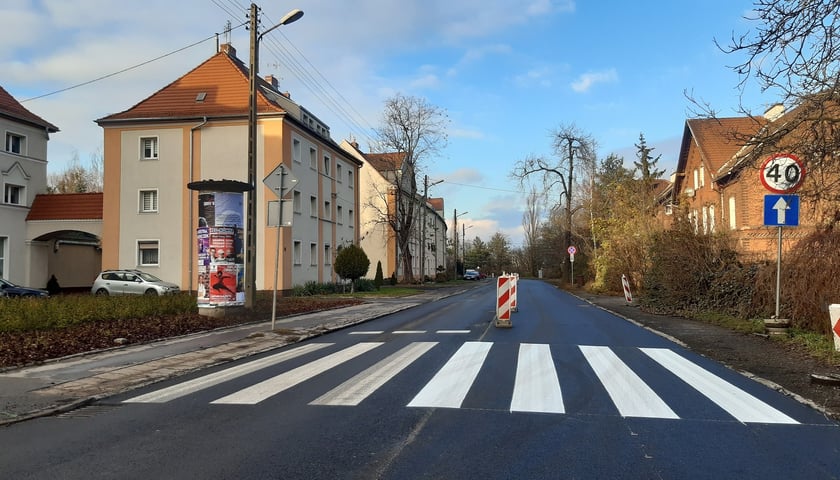 Ulica Mościckiego z nowym asfaltem i pasami dla pieszych, obok domy
