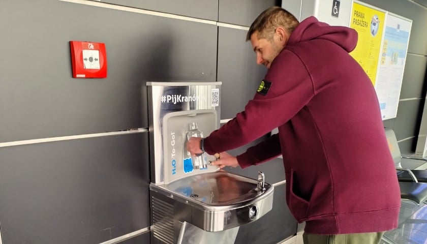Dawid przed odlotem do Malagi napełnia kranówką bidon, który dostał od MPWiK Wrocław