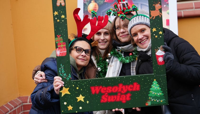 Uczestniczki spotkania w Leśnicy. Cztery kobiety trzymają ramkę z napisem Wesołych Świąt. 