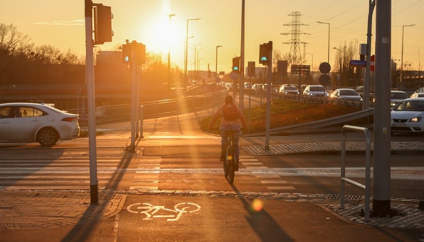 Na alei Wielkiej Wyspy wszystkie drogi rowerowe i chodniki są już gotowe. Na zdjęciu rowerzysta w blasku zachodzącego słońca 