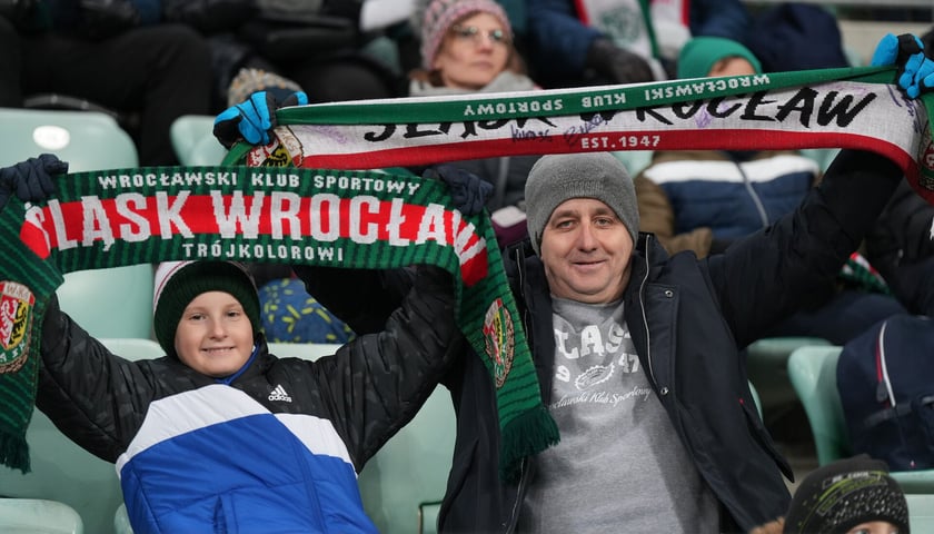 Kibice z szalikami na meczu Śląsk - Radomiak na Tarczyński Arenie, na pierwszym planie z lewej chłopiec, obok mężczyzna