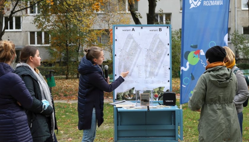 Projektantka omawia na podwórku koncepcję jego odnowy.