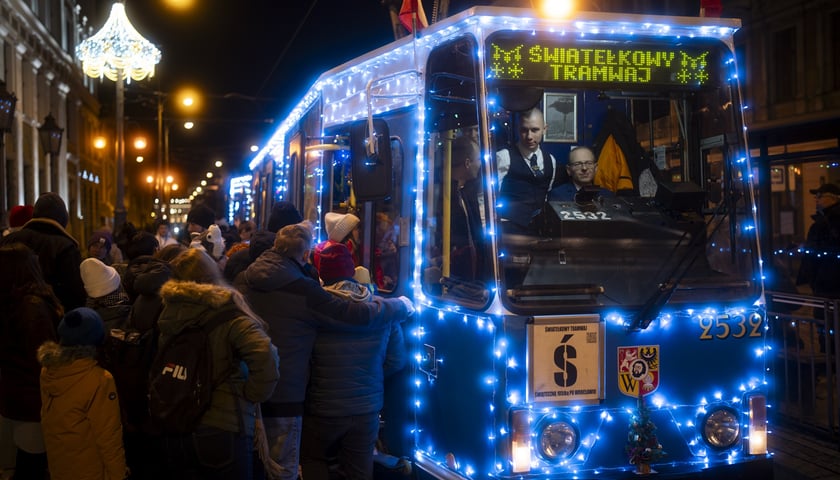 Światełkowy Tramwaj, z lewej tłum wsiadających pasażerów.