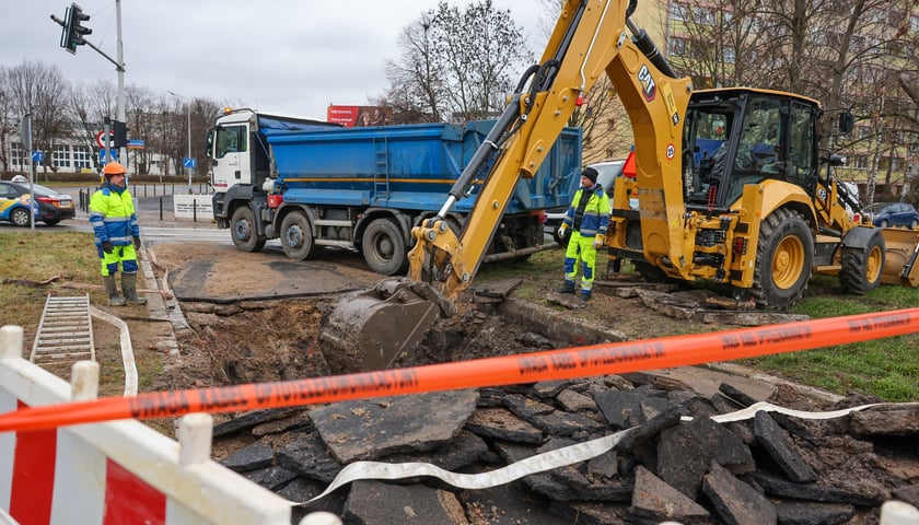 Prace w miejscu awarii wodociągowej przy Zaporoskiej, widać robotników, ciężarówkę i koparkę