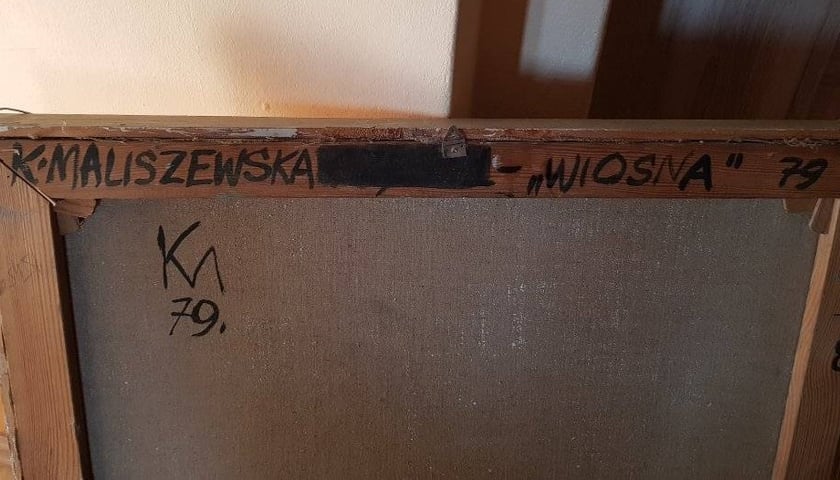 Tył obrazu z podpisem autorki na ramie.