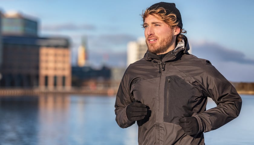 Biegnący mężczyzna, w tle rzeka i miasto