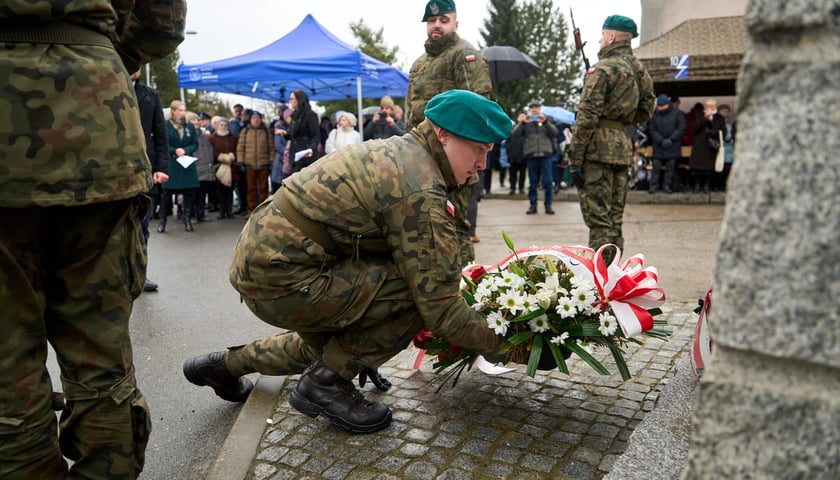 Żołnierz składający kwiaty pod pomnikiem więźniów filii obozu Gross-Rosen w Leśnicy. Wrocław, 23.01.2025