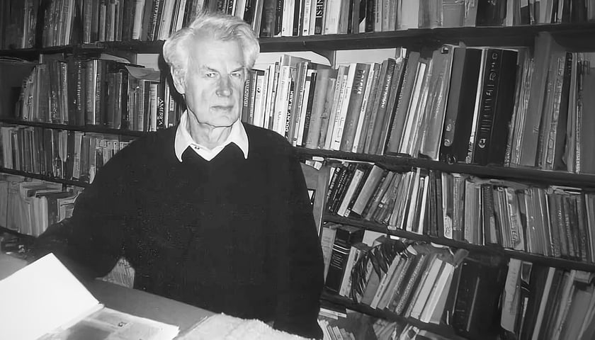 Prof. Jan Mycielski. Na zdjęciu widać dojrzałego mężczyznę siedzącego przy stole