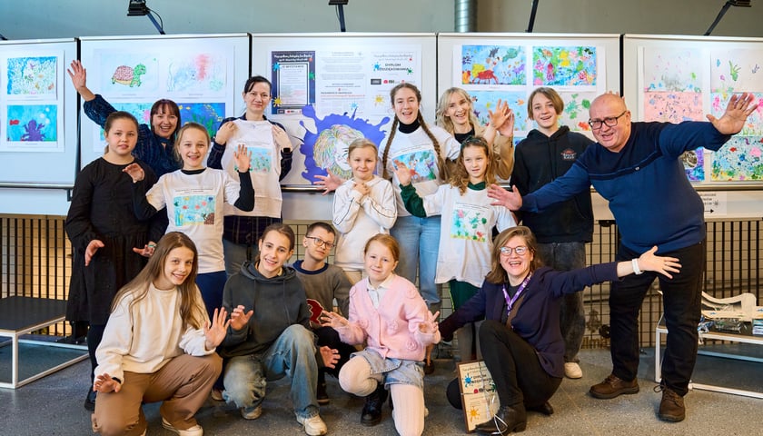 Laureaci i wyróżnieni w III edycji Międzyszkolnego Konkursu Plastycznego dla Powiatu Wrocławskiego "Nasze spotkania z twórczością Jana Brzechwy" z organizatorami na tle wystawy w Kinie Nowe Horyzonty