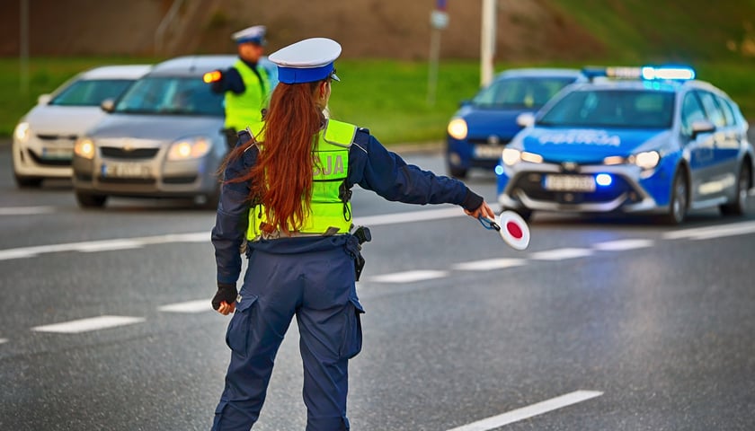 Zdjęcie ilustracyjne, policjantka zatrzymująca pojazdy na drodze