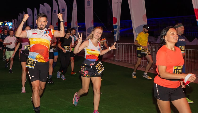 Zdjęcie archiwalne z 10. wrocławskiego półmaratonu - uczestnicy biegu machają do fotografa