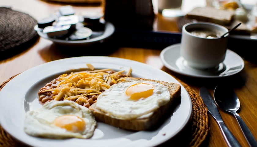 Na zdjęciu talerz ze śniadaniem angielskim oraz filiżanka kawy. Sprawdź, jakie nowe lokale gastronomiczne otworzyły się we Wrocławiu!