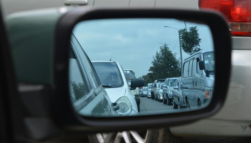 Lusterko samochodu, w którym odbija się korek - zdjęcie ilustracyjne