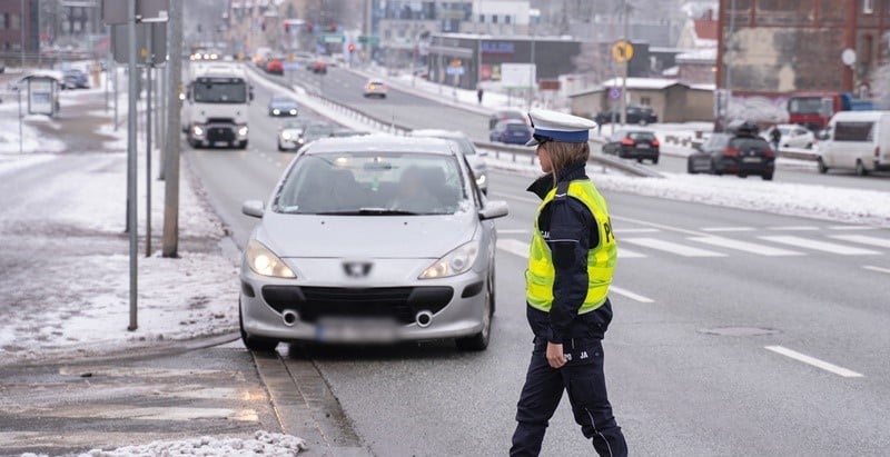 Policjantka zatrzymująca samochód do kontroli.