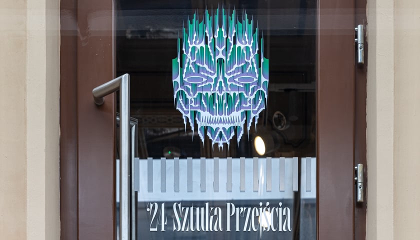 Zdjęcie drzwi z grafiką promującą wystawę.