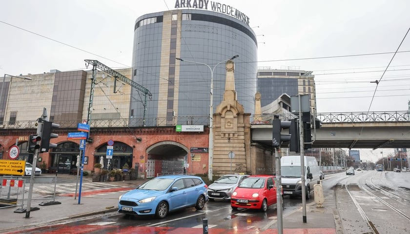Samochody jadące w kierunku centrum od Arkad Wrocławskich (w tle) i nasypu
