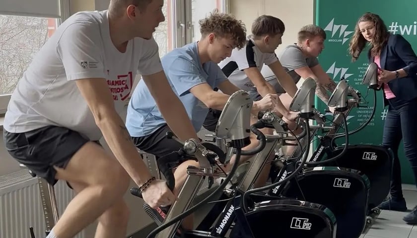 Eksperyment AWF Wrocław z udziałem studentów. Na zdjęciu młodzi mężczyźni na rowerach stacjonarnych
