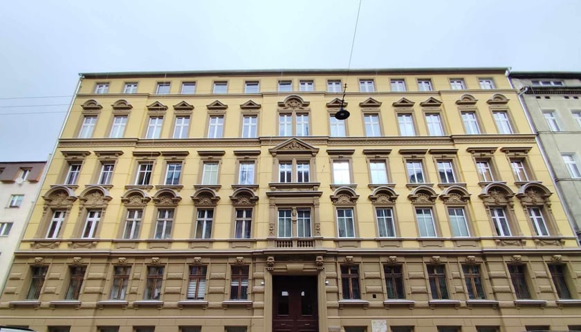 Beżowo-brązowa elewacja wyremontowanej kamienicy przy ul. Komuny Paryskiej we Wrocławiu